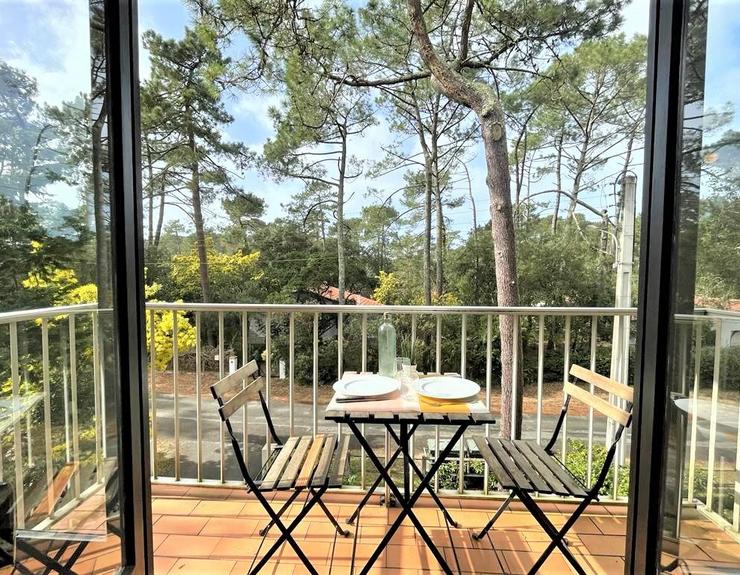 Terrasse aménagée avec table et chaises offrant une vue sur la nature.