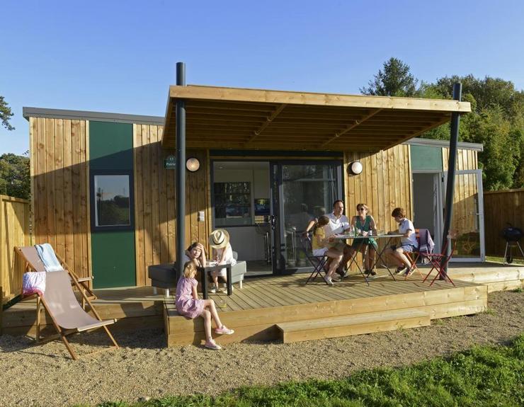 Hébergement touristique contemporain en bois avec terrasse et espace extérieur.